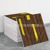A stack of brown marble peel-and-stick tiles with gold accents displayed on a gray surface.