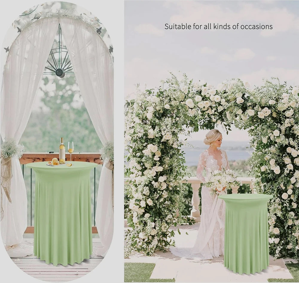 A light green stretch tablecloth draped on a round table in an outdoor wedding or event setting surrounded by white floral ar