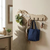Rustic wooden key holder with a heart accent and four hooks mounted on a beige wall.