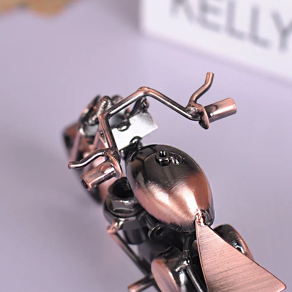 A close-up of a handcrafted metal motorcycle model featuring intricate details and a metallic finish.