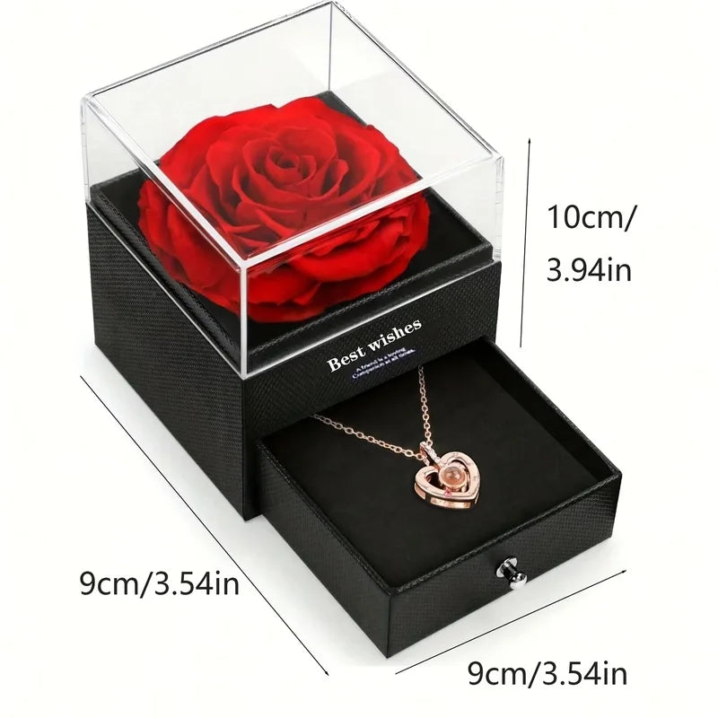 Un coffret noir avec une rose rouge conservée et un collier en forme de cœur doré.
