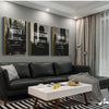 A set of three framed black and white wall art prints featuring motivational words Hustle Execution Grind displayed on a gray
