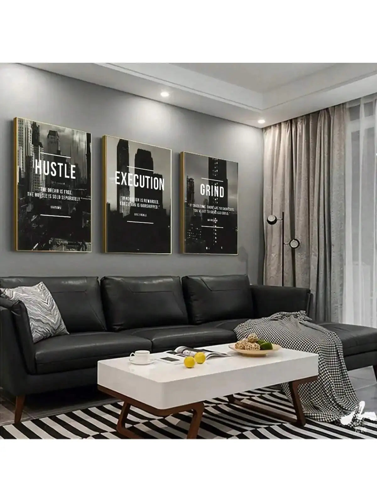 A set of three framed black and white wall art prints featuring motivational words Hustle Execution Grind displayed on a gray