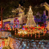 Outdoor Christmas display featuring solar-powered candy cane lights illuminating a pathway and tree.
