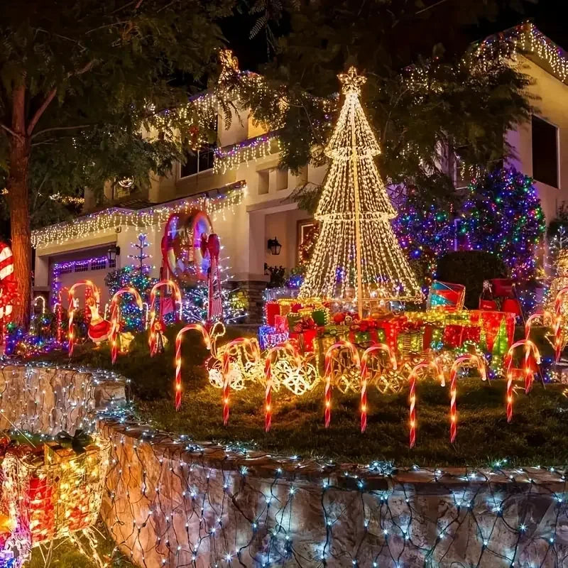 Outdoor Christmas display featuring solar-powered candy cane lights illuminating a pathway and tree.