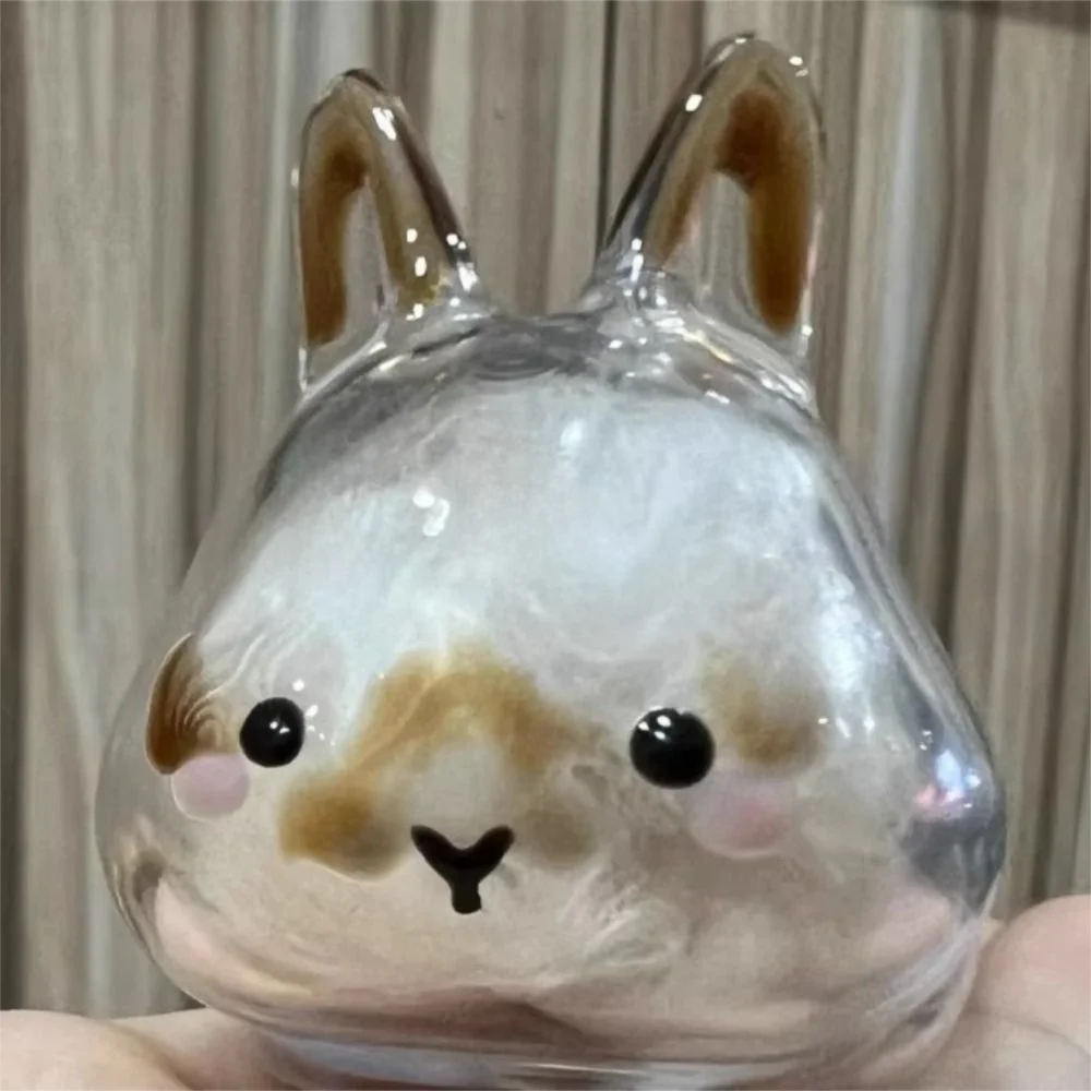 A clear glass figurine shaped like a rabbit with brown accents and black eyes.