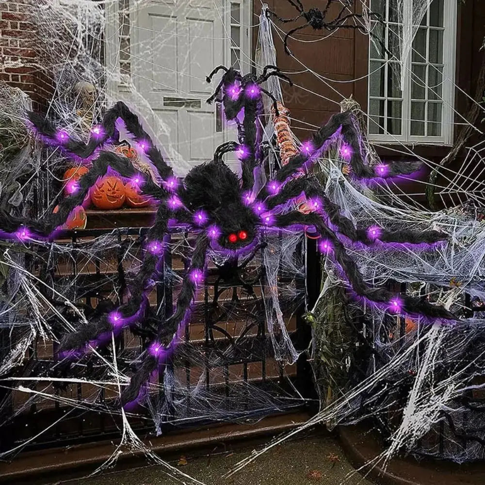 A large black spider web decoration with purple LED lights is displayed outdoors.
