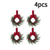 Four artificial Christmas wreaths with red berries and velvet bows.