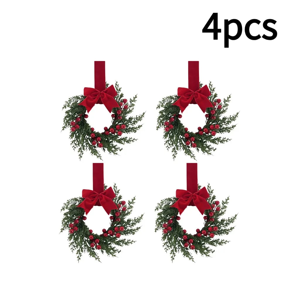 Four artificial Christmas wreaths with red berries and velvet bows.