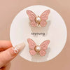 A pair of pink butterfly waist tightener clips with pearl accents displayed on a white background.