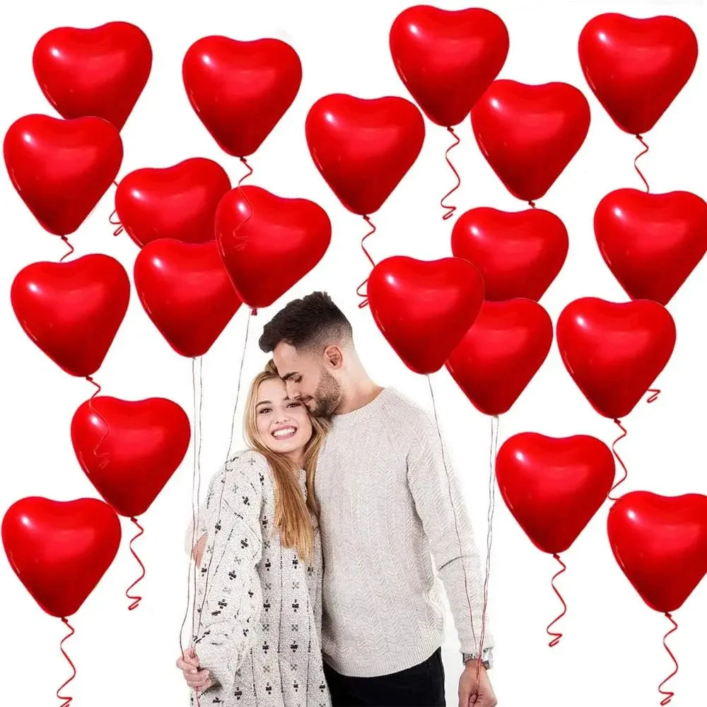 A couple is holding a red heart-shaped latex balloon, surrounded by many red heart balloons.
