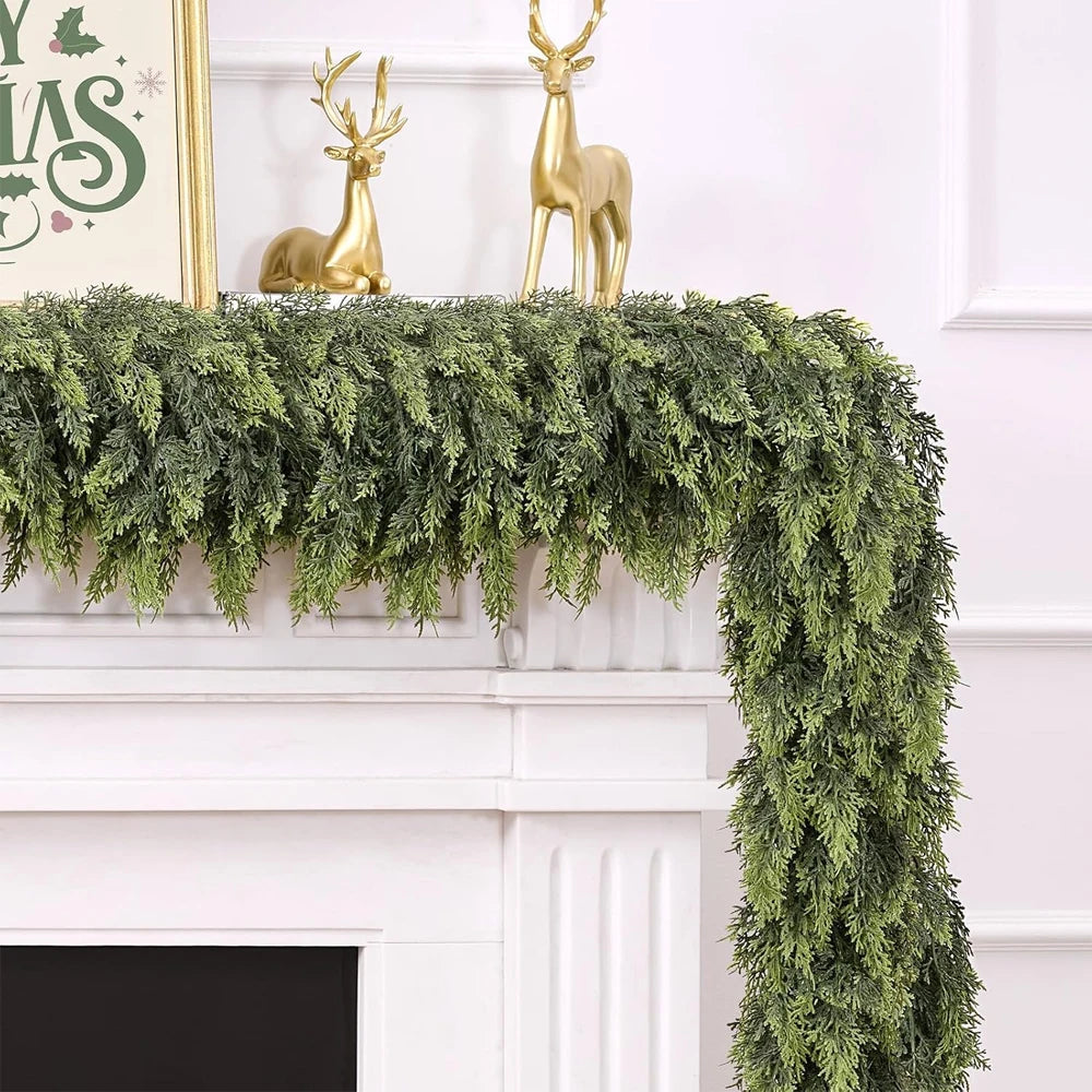 Artificial cedar garland with gold deer figurines decorating a white fireplace mantel