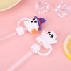 White silicone straw covers with purple accents and clear ice cubes on a pink background