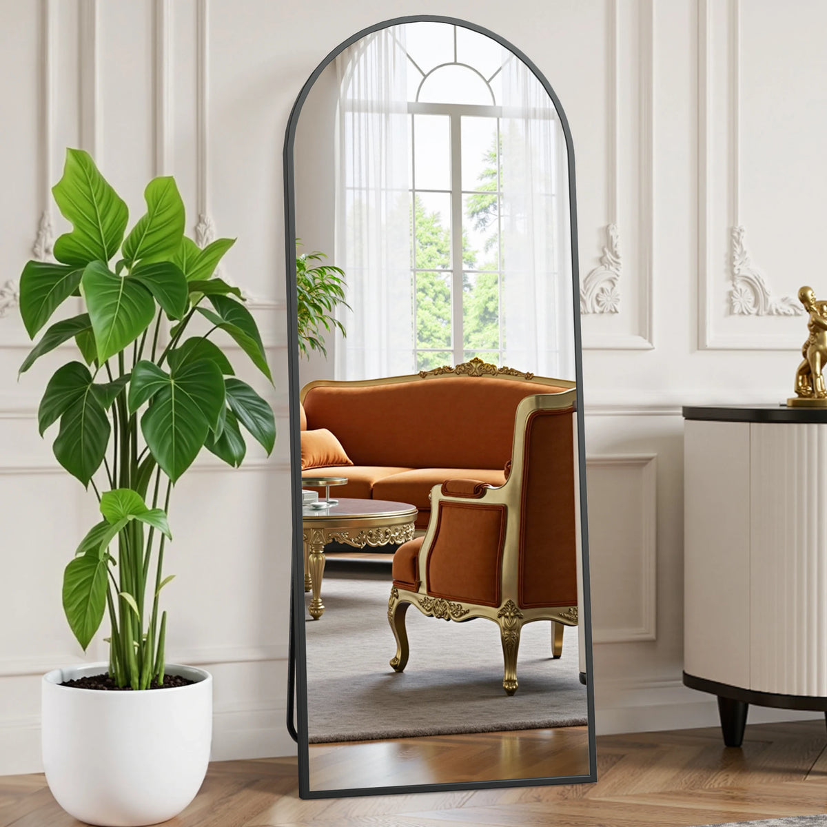 A full length body mirror with a black aluminum frame reflecting an interior room.