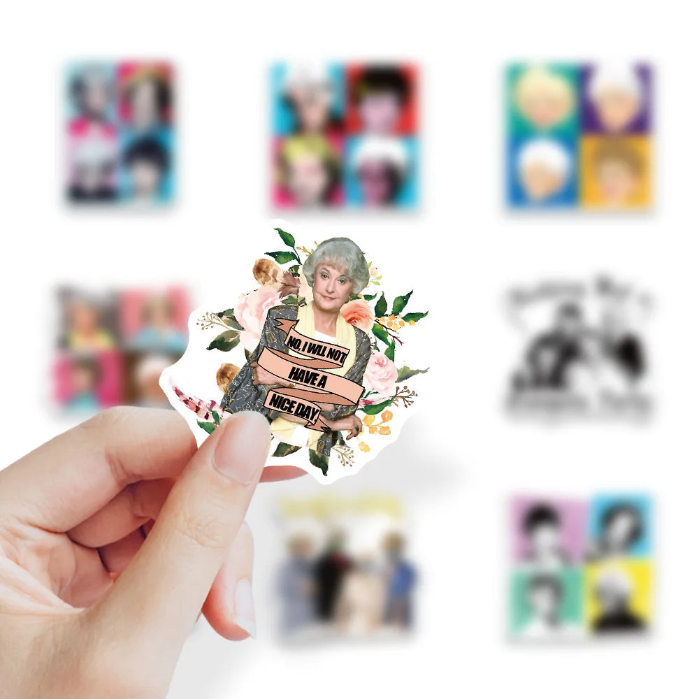 A hand holds a sticker pack featuring various Golden Girls characters for DIY decoration.