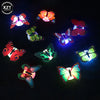 A collection of glowing 3D LED butterflies in various colors and patterns against a dark background.