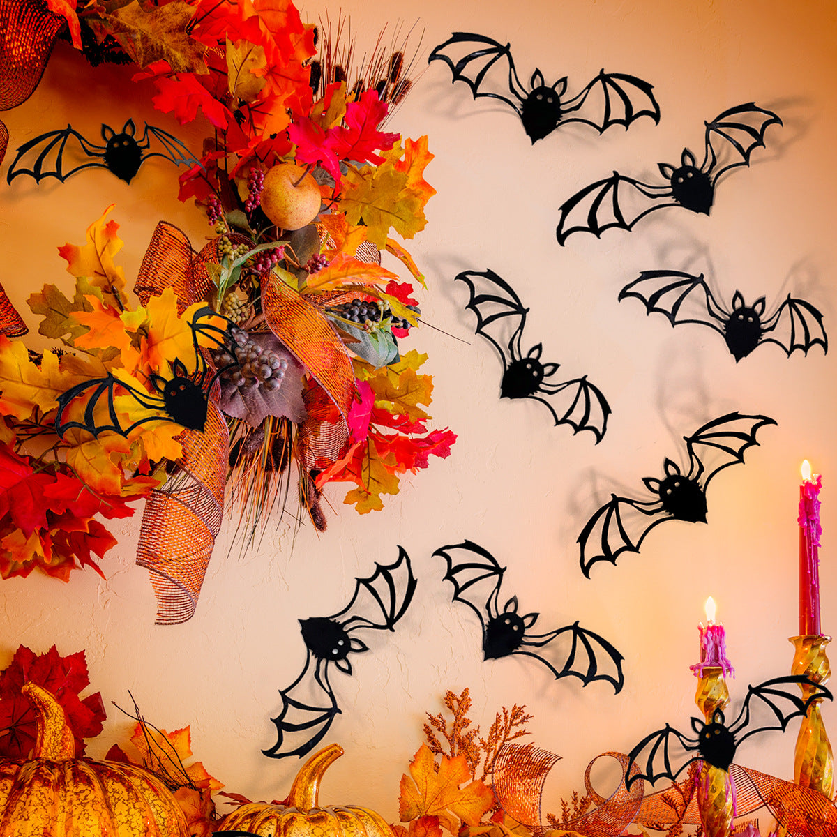 A wall decorated with black bat silhouettes made of autumn leaves and foliage.