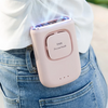 A pink portable multi-use cooling fan is held in a person's hand against a denim background.