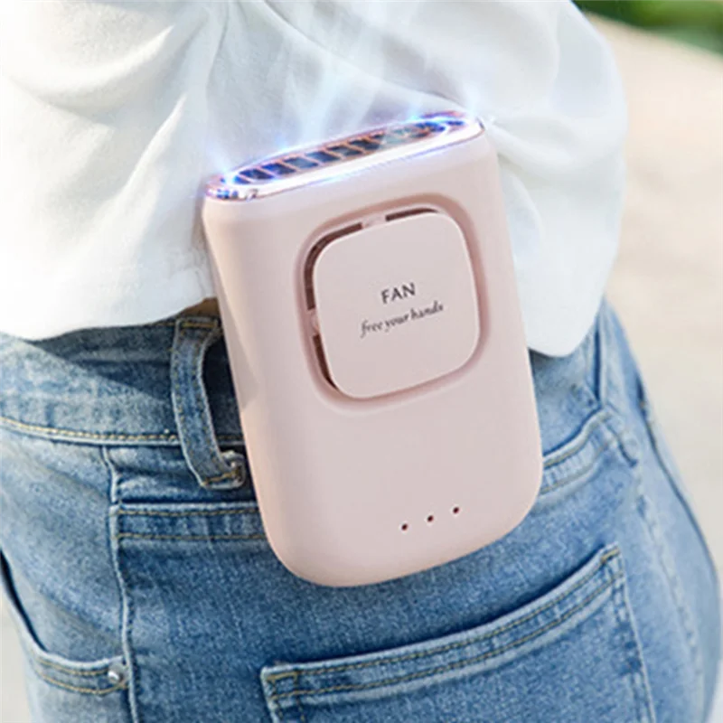 A pink portable multi-use cooling fan is held in a person's hand against a denim background.