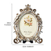 Vintage gold oval resin picture frame with ornate detailing and a white background