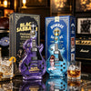 A purple guitar-shaped glass whiskey decanter labeled Black Sabbath Paranoid whisky displayed next to a blue Bombay gin bottl