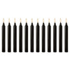A set of twelve black taper candles standing upright in a row.