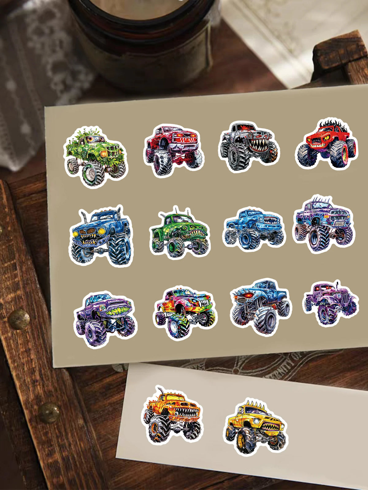 A collection of 12 monster truck decals featuring various colors and designs on a beige background.