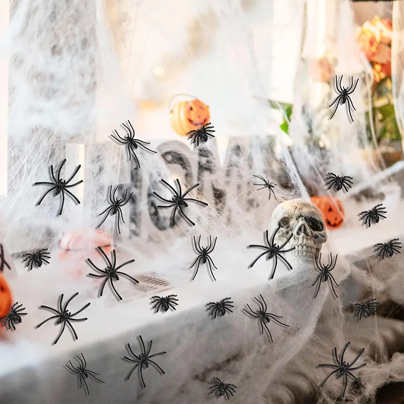 A display of realistic mini plastic spiders for Halloween decor, suspended in sheer white fabric.