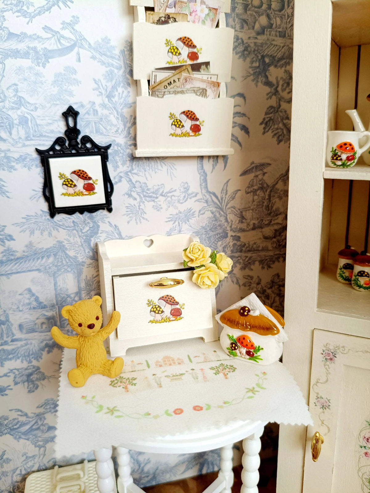A display of handcrafted miniature mushroom tableware and decorative items for dollhouses.