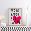 A framed canvas print featuring the text More Amor Por Favor in black and bright pink on a white background.
