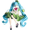 A PVC collectible figurine of Hatsune Miku with long blue hair and a green dress.