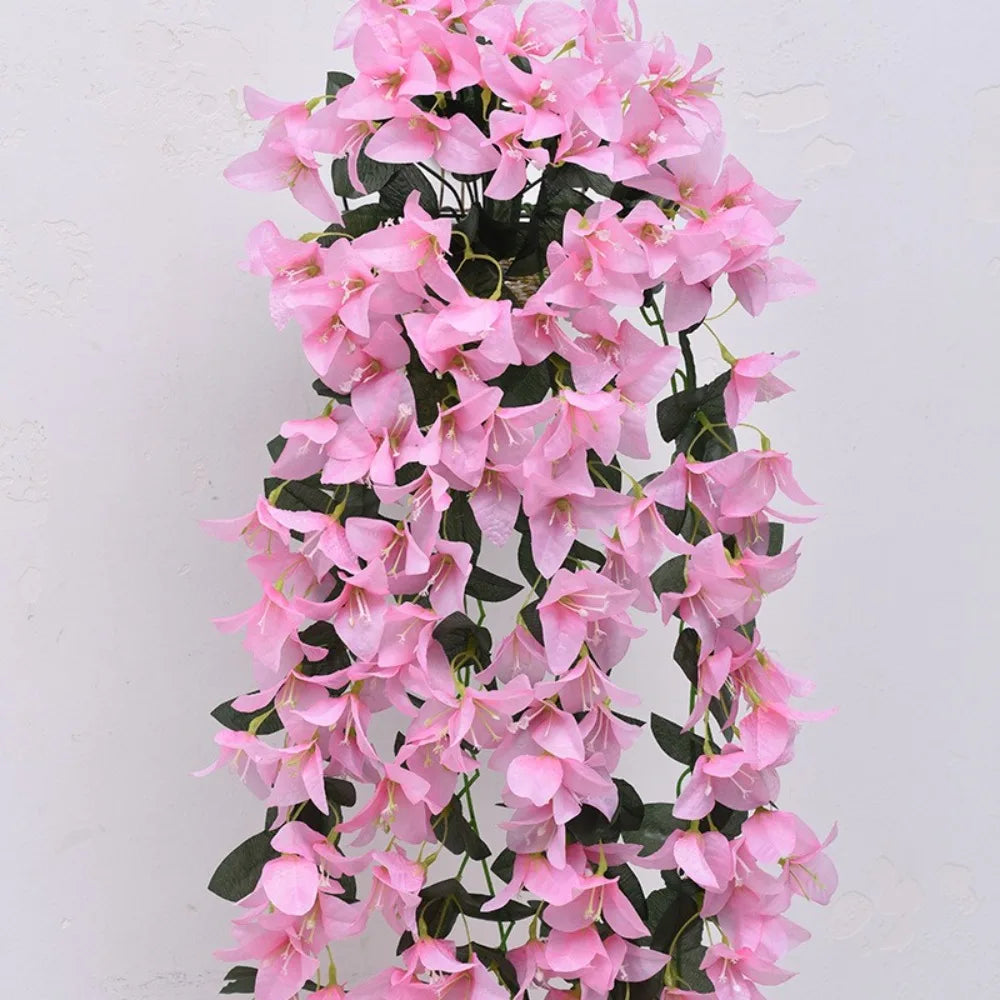 A cascading arrangement of pink faux bougainvillea vine flowers on a dark green stem.