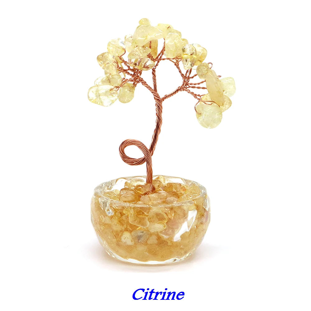 A crystal healing gemstone bonsai featuring yellow citrine crystals on a wooden branch set in a glass bowl.