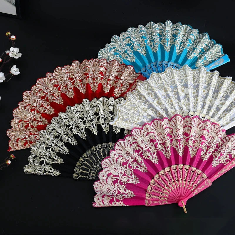 A collection of five elegant folding fans in various colors including red, pink, white, and blue, displayed on a dark surface