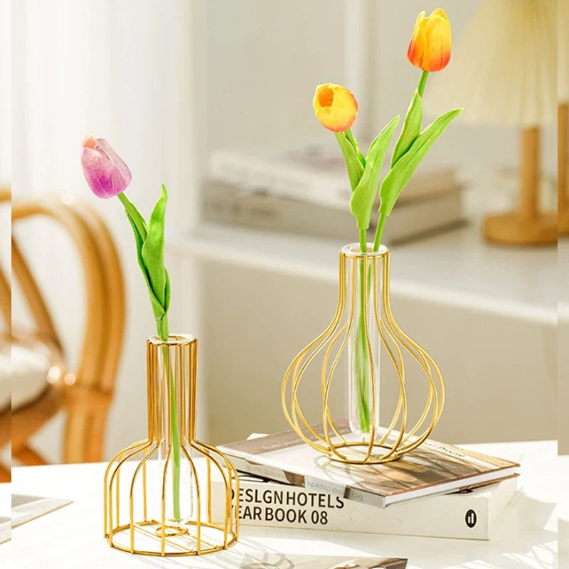 A handcrafted gold iron hollow vase holds a single yellow tulip in a modern interior setting.