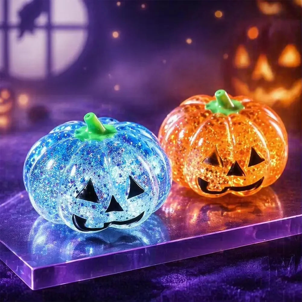 Two glowing Halloween pumpkins, one blue glitter and one orange glitter, resting on a purple surface.