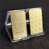 A clear plastic case holds two gold plated bullion ingots labeled Credit Suisse with 999.9 purity.