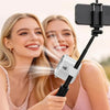 Two women smiling while using an adjustable clip-on mini electric fan for hair drying
