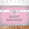 Pink glitter backdrop banner with a white bow and birthday text on a wooden surface.