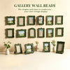 A gallery wall display featuring multiple vintage baroque resin picture frames in various sizes and greens.