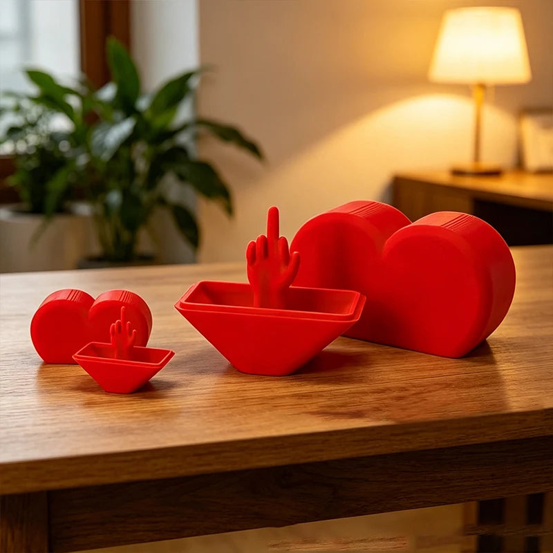 Red heart-shaped novelty desk decor featuring three silicone utensils on a wooden table.