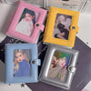 Three compact photo card holders in pink yellow and silver are displayed on a dark surface.