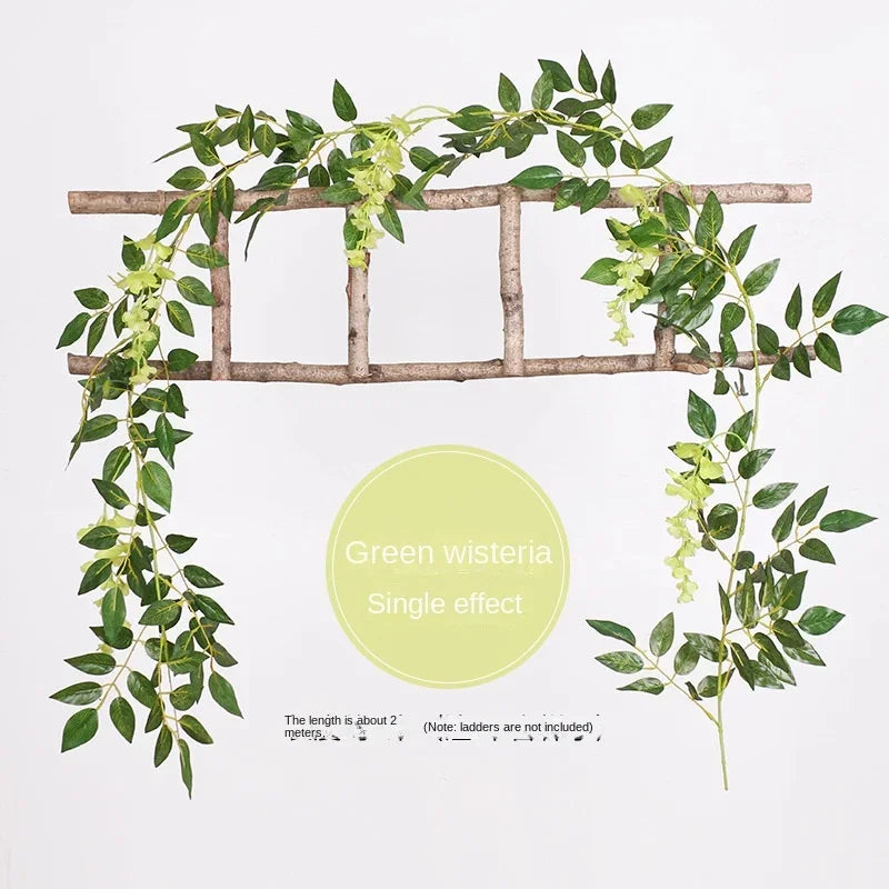 A green wisteria vine garland draped over a wooden trellis for wedding or home decor.