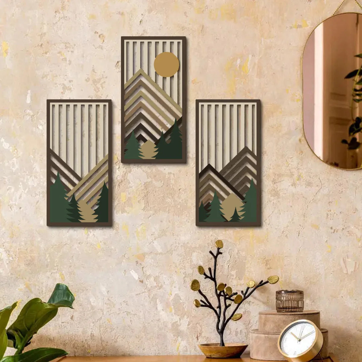 Drei vertikale Holz-Wandkunstwerke mit Berg- und Baumlandschaften an einer strukturierten beige Wand.