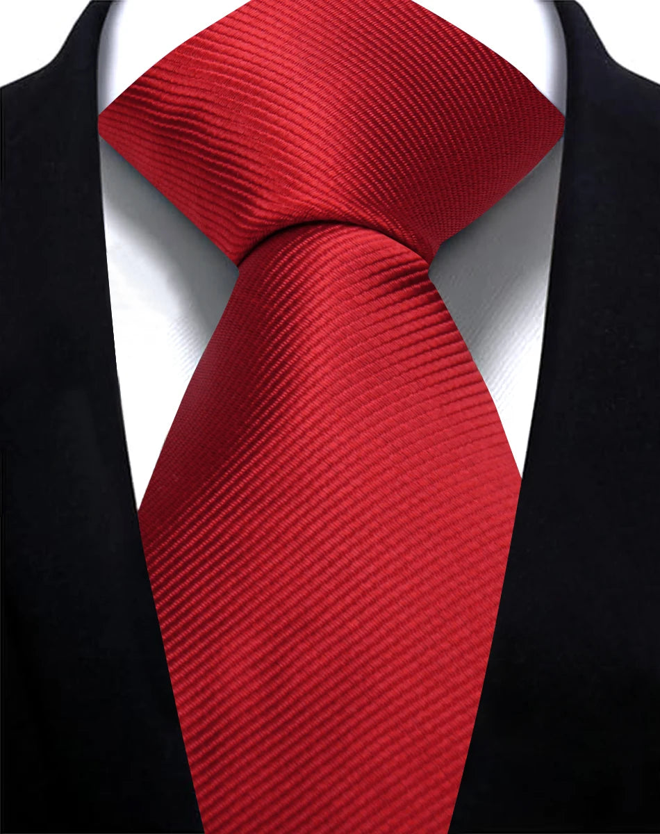 A red silk necktie tied in a knot against a black suit jacket.