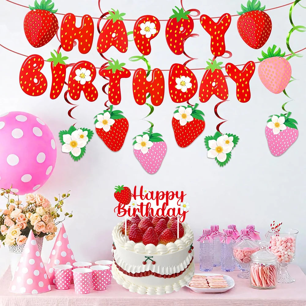 A strawberry birthday party decoration set featuring a banner, cake toppers, and pink and red elements.