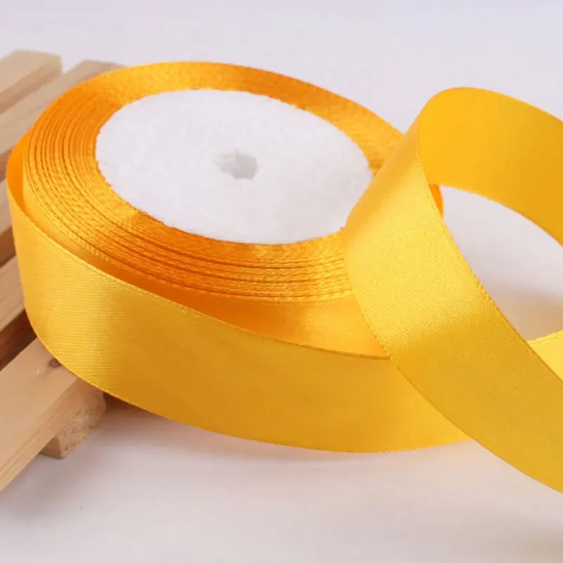 Roll of gold yellow satin ribbon with white stuffing for crafts and gift wrapping
