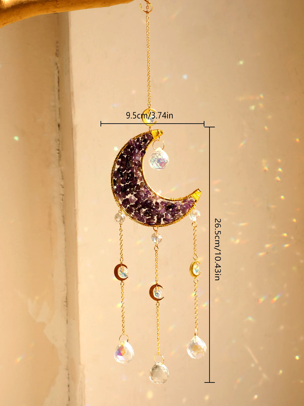 A hanging crystal dreamcatcher featuring a purple crescent moon and dangling clear crystals.