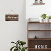 Rustic wooden wall sign with the text This is us our life our story our home mounted on a white wall