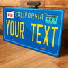 A blue metal sign with yellow text that reads Your Text and features California state information.